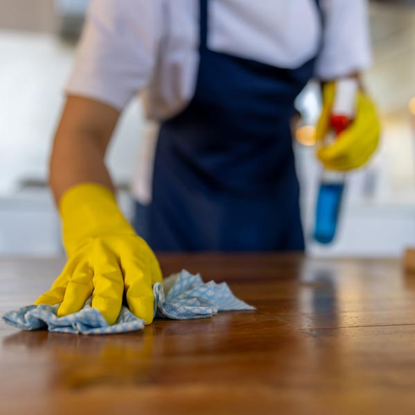 person cleaning wood table top