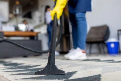 person vacuuming carpet
